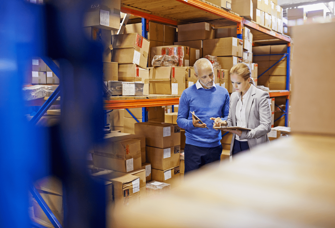 A warehouse manager and an employee checking ensuring the warehouse management system fits the requirements.