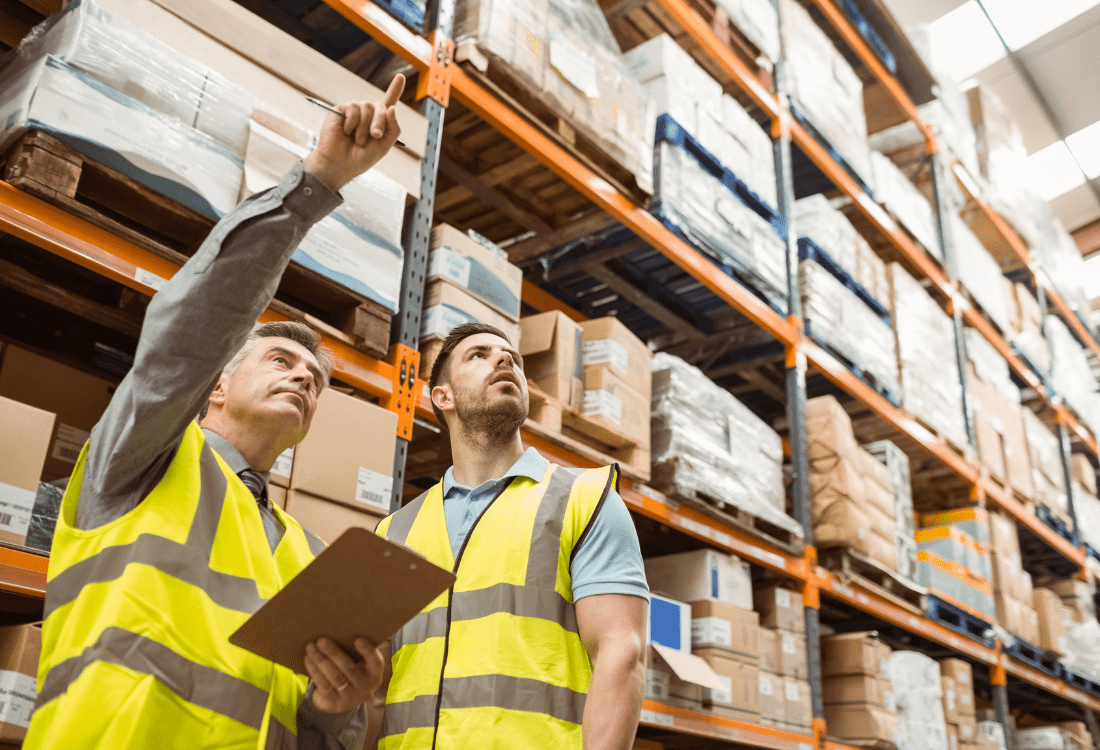 Two eCommerce warehouse workers trying to find ways to optimise their eWarehouse. 