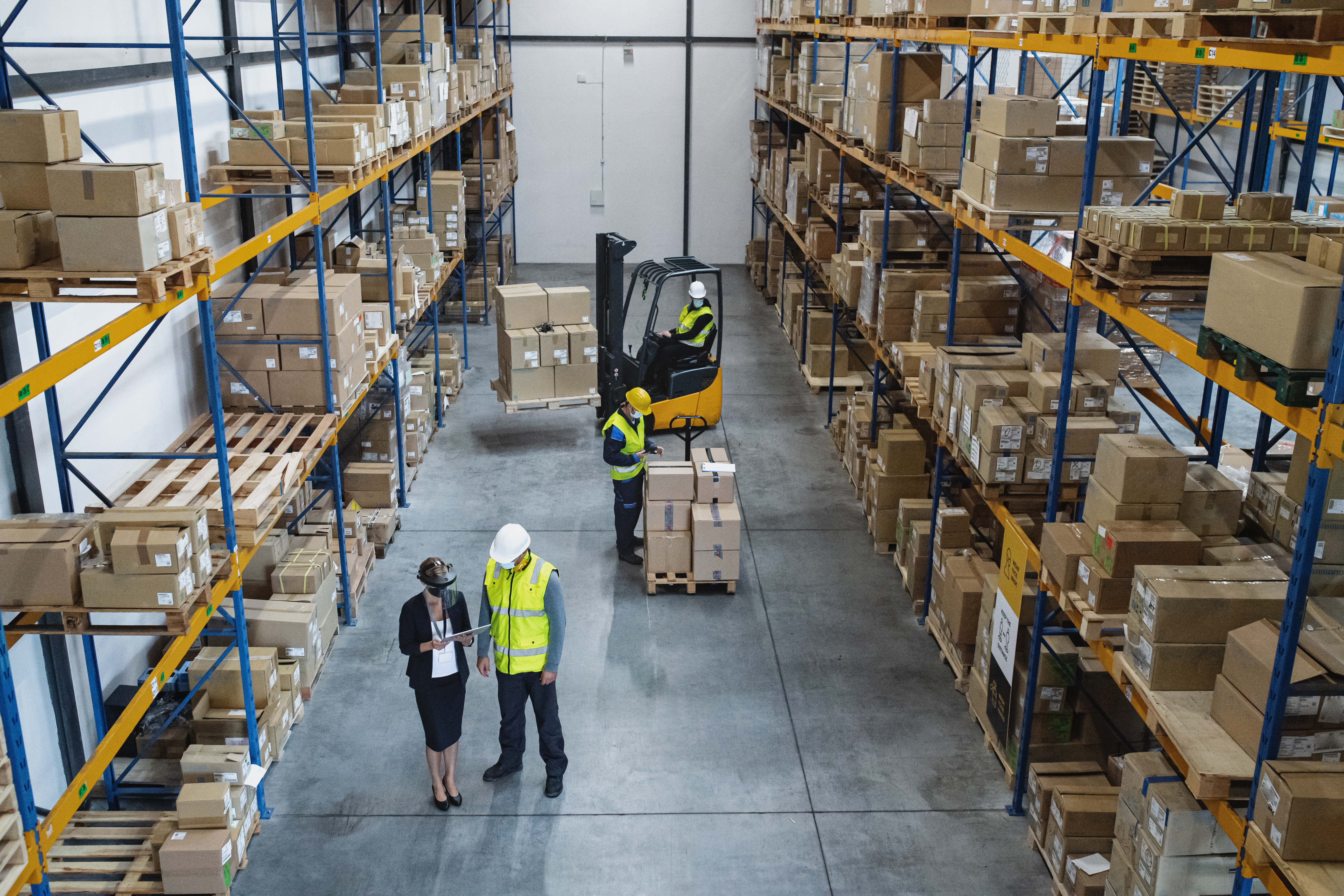 Warehouse worker organising inventory onto storage racks, representing efficient stock put-away processes in warehouse operations.
